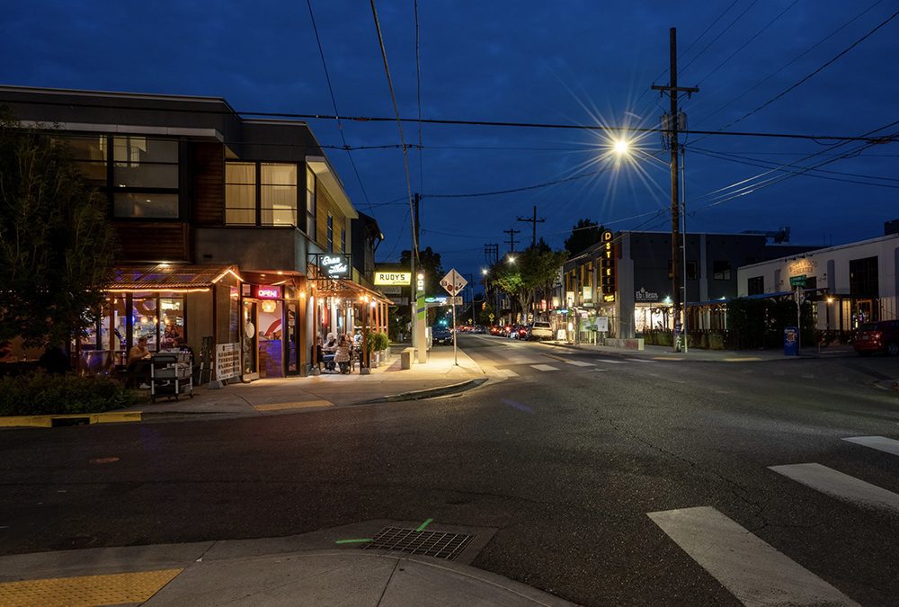 man intersection in Portland lit up at night