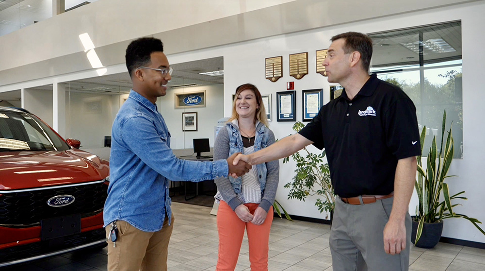 people shaking hands at Landmark Ford car dealership